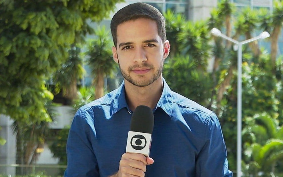 Gabriel Luiz em foto publicada no Instagram; ele veste uma camisa azul e segura um microfone da Globo com a mão direita