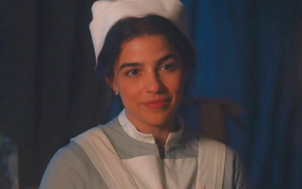 Gabriela Medvedovski com uniforme de enfermeira em cena como Pilar da novela Nos Tempos do Imperador