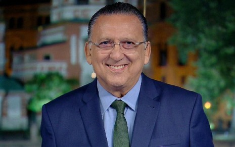Galvão Bueno sorri numa foto com um torno azul e uma gravata verde