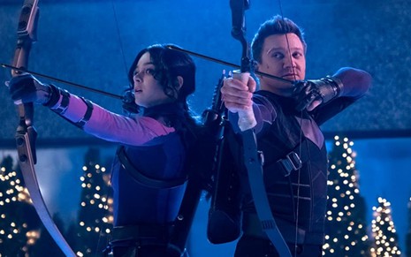 Hailee Steinfeld e Jeremy Renner se preparam para atirar flechas em cena do último episódio de Gavião Arqueiro