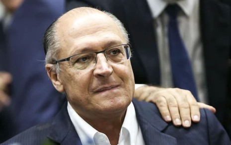 Geraldo Alckmin tem o semblante sério, com a boca comprimida e as sobrancelhas franzidas; ele usa um terno com gravata azul.