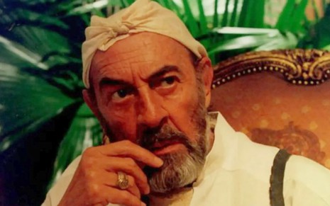 Raul Cortez como Geremias Berdinazzi em O Rei do Gado (1996), com camisa branca e pano branco na cabeça