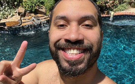Gil do Vigor sorri para a câmera em foto publicada nas redes sociais; ao fundo, é possível ver uma piscina