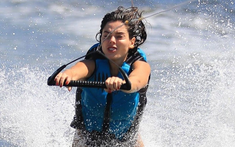 Giovanna Lancellotti usa colete salva-vidas e faz careta na água ao praticar wakeboard