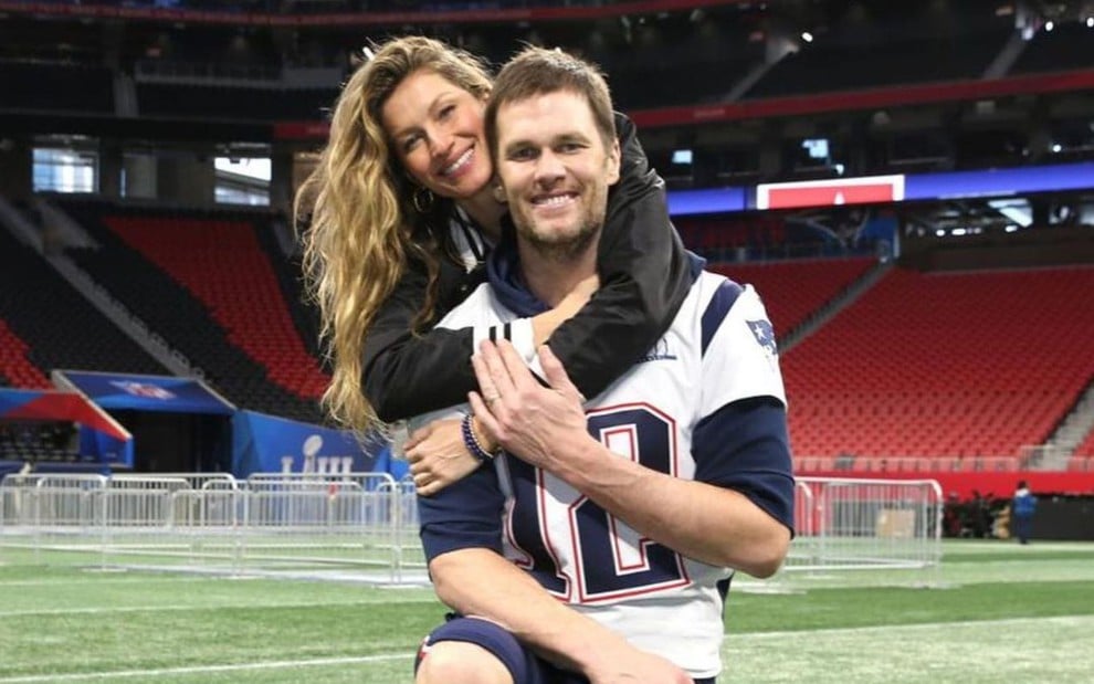 Imagem de Gisele Bündchen abraçando Tom Brady em um campo de futebol americano