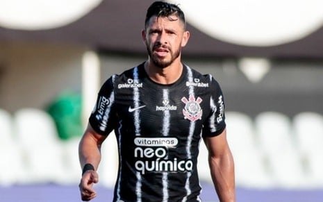 Giuliano, meia do Corinthains, com uma camisa preta e branca do clube paulistano em um jogo contra o Santos no Campeonato Brasileiro