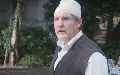 O ator Antonio Calloni caracterizado como o Matias com bandagens ao redor da cabeça em cena de Além da Ilusão