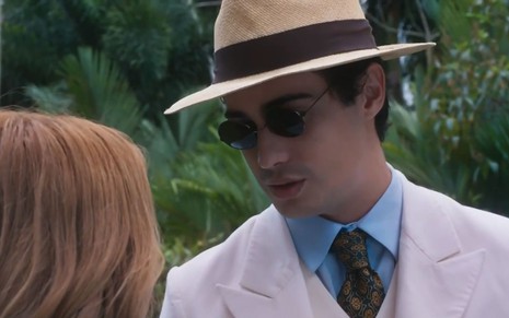 Joaquim (Danilo Mesquita) está de óculos escuro e chapéu em cena de Além da Ilusão, novela das seis da Globo