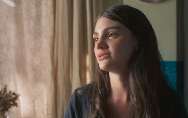 Olívia (Debora Ozório) olha para o lado e chora em cena de Além da Ilusão, novela das seis da Globo