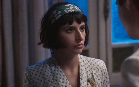 Iolanda (Duda Brack) usa lenço no cabelo e encara fixamente Joaquim (Danilo Mesquita), que não parece na foto, em cena de Além da Ilusão