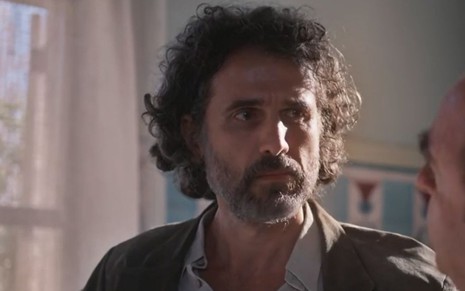 Leônidas (Eriberto Leão) está em pé em hospital em cena de Além da Ilusão, novela das seis da Globo