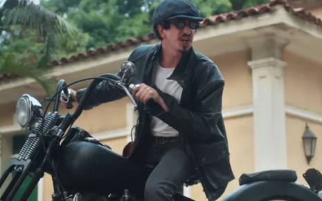 Nelsinho (Johnny Massaro) está em cima de moto e está raivoso em cena de Além da Ilusão, novela das seis da Globo
