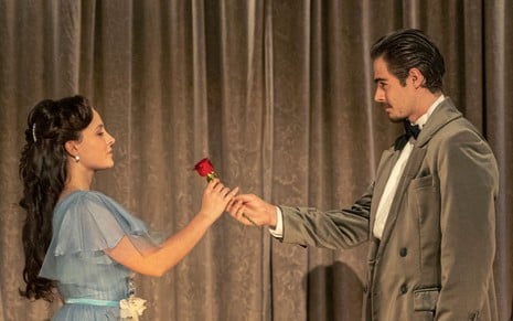 Larissa Manoela e Rafael Vitti gravam cena ambos segurando uma flor, como Elisa e Davi, de Além da Ilusão