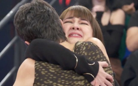 Sandra Annenberg, de costas, abraça a atriz Klara Castanho, visivelmente emocionada, no palco do Altas Horas