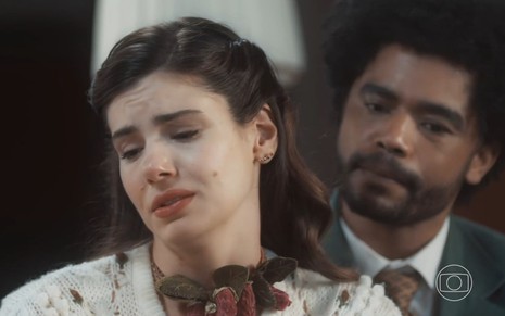 Camila Queiroz tem expressão de choro em cena de Amor Perfeito; ela é observada por Diogo Almeida