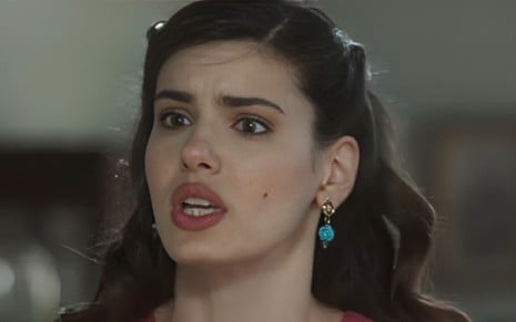A atriz Camila Queiroz está com a boca aberta, falando, em cena da novela Amor Perfeito como a mocinha Marê