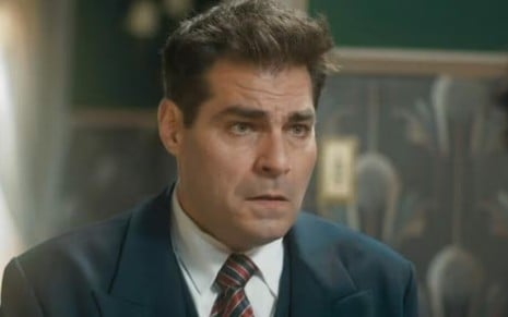 O ator Thiago Lacerda está com expressão de espanto em cena de Amor Perfeito em que usa terno e gravata caracterizado como Gaspar