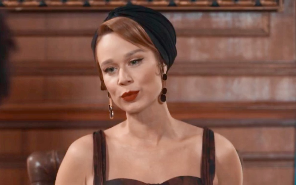 A atriz Mariana Ximenes usa acessório preto na cabeça e está maquiada em cena de Amor Perfeito como GIlda