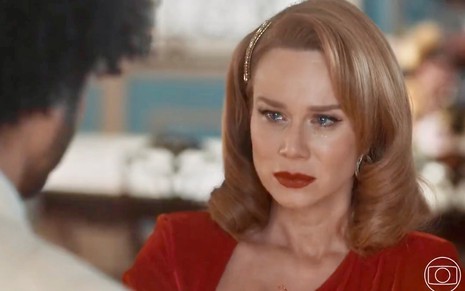 A atriz Mariana Ximenes usa vestido vermelho e tem os olhos cheios de lágrimas em cena de Amor Perfeito como Gilda