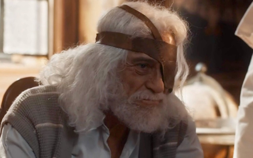 O ator Paulo Gorgulho está com barba e cabelos grandes e usa um tapa-olho em cena de Amor Perfeito como Leonel