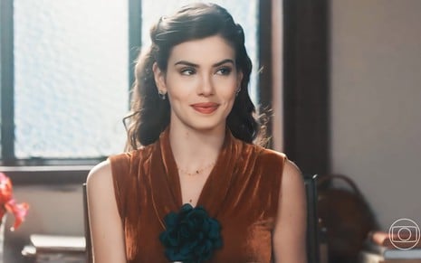 A atriz Camila Queiroz está com expressão sapeca e exibe um leve sorriso em cena da novela Amor Perfeito como Marê