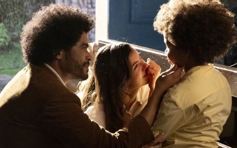 Orlando (Diogo Almeida) e Marê (Camila Queiroz) olham emocionados para Marcelino (Levi Asaf) em cena de Amor Perfeito
