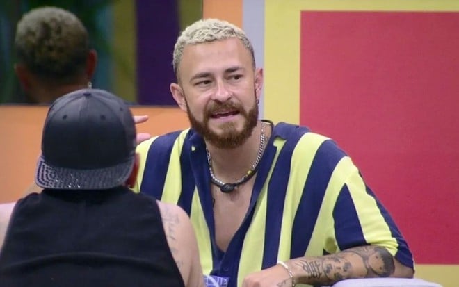 Fred Desimpedidos na varanda do BBB 23 com uma camisa listrada azul e amarela