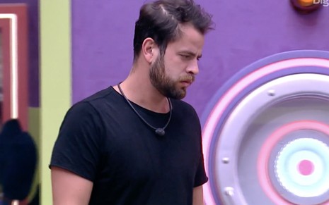 Gustavo com uma camisa preta e expressão séria na sala do Big Brother Brasil 22