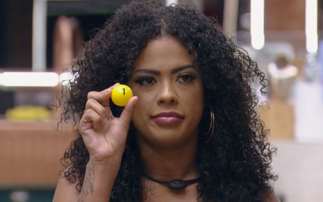 Marvvila segura uma bola amarela com o número um na sala do BBB 23