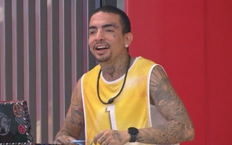 MC Guimê sorri enquanto segura o colar do anjo no BBB 23