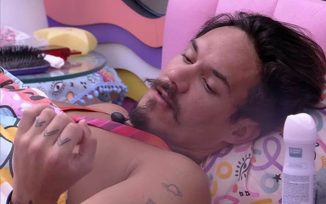 Eliezer está deitado em cama no quarto lollipop do BBB 22