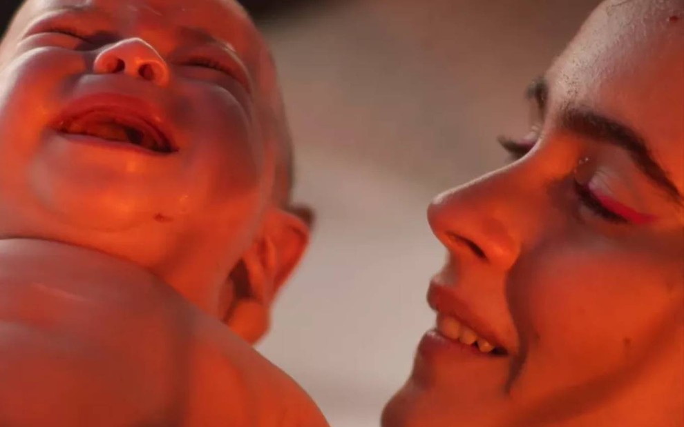 Atriz Valentina Herszage surge de perfil e olha para bebê
