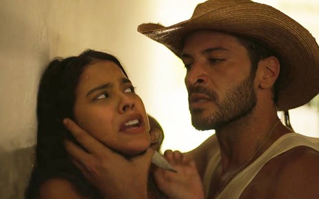 Ator Leandro Lima segura faca no pescoço da atriz Bella Campos em cena de Pantanal