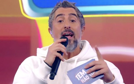 O apresentador Marcos Mion fala em microfone no programa Caldeirão no último sábado (30), na Globo