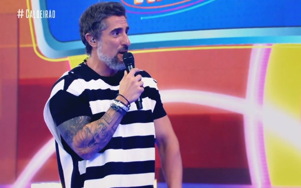 O apresentador Marcos Mion no programa Caldeirão, da Globo, em que ele aparece de camiseta e com tatuagens à mostra