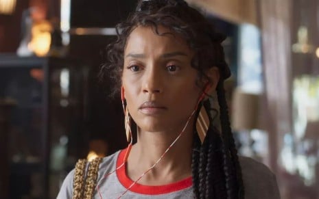 Taís Araujo caracterizada como Anita; atriz não usa maquiagem, tem os cabelos presos em tranças frouxas e ostenta uma expressão perturbada em cena de Cara e Coragem