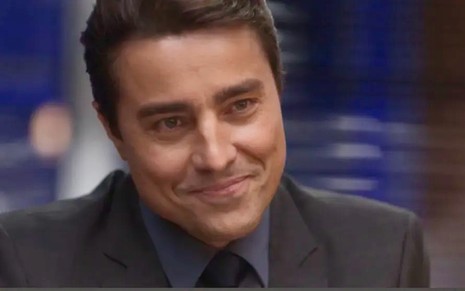 O ator Ricardo Pereira usa terno e gravata escuros como seu personagem Danilo da novela Cara e Coragem