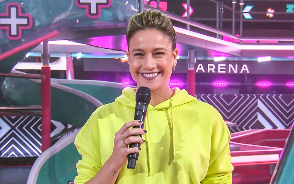 Fernanda Gentil sorri enquanto segura microfone em foto de divulgação do programa Zig Zag Arena, da Globo