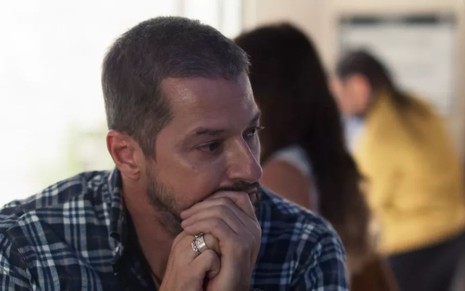 Moa (Marcelo Serrado) está pensativo em cena de Cara e Coragem