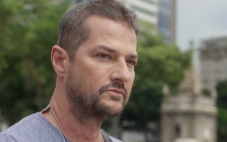 O ator Marcelo Serrado usa camiseta cinza, está com barba por fazer, caracterizado como Moa em cena de Cara e Coragem, nova novela das sete da Globo