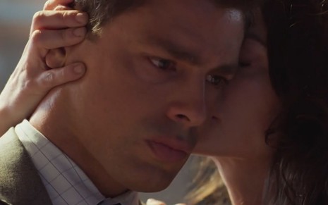 Christian/Renato (Cauã Reymond) é abraçado por Bárbara (Alinne Moraes), que segura a orelha dele em cena de Um Lugar ao Sol