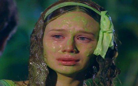 Mariana Ximenes tem os cabelos e as roupas sujas de tinta verde; a atriz ostenta uma expressão chorosa em cena de Chocolate com Pimenta