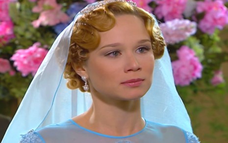 Mariana Ximenes caracterizada como Ana Francisca; ela usa um vestido de noiva azul e tem o semblante abatido em cena de Chocolate com Pimenta