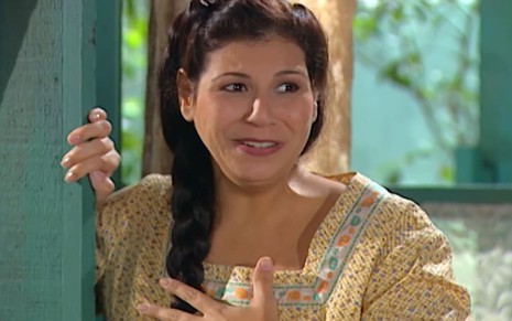 Carla Daniel caracterizada como Dália; ela tem o semblante sério e abalado em cena de Chocolate com Pimenta