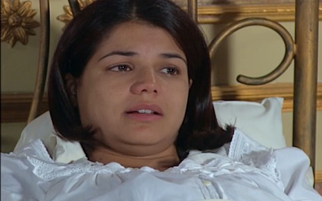 Nivea Stelmann caracterizada como Graça em Chocolate com Pimenta; atriz uma camisola branca e parece desolada em cena da novela