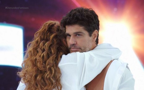 Vestida de branco, a dançarina Juliana Paiva abraça Bruno Cabrerizo no palco do Domingão com Huck, da Globo