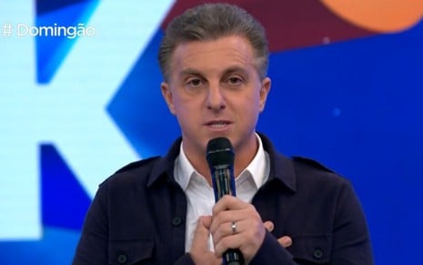 O apresentador Luciano Huck olha sério enquanto segura um microfone no programa Domingão com Huck de domingo, 5 de setembro, dia de estreia da atração