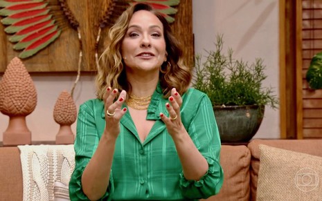 Com blusa verde e mãos levantadas para cima, Maria Beltrão faz a abertura do É de Casa deste sábado (6) na Globo