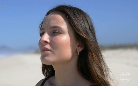 Larissa Manoela tem expressão pensativa na praia em reportagem do Fantástico