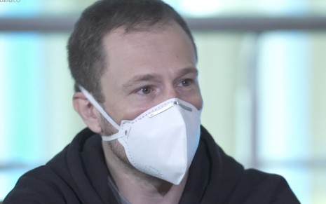 O apresentador Tiago Leifert com uma máscara PFF-2 em um hotel